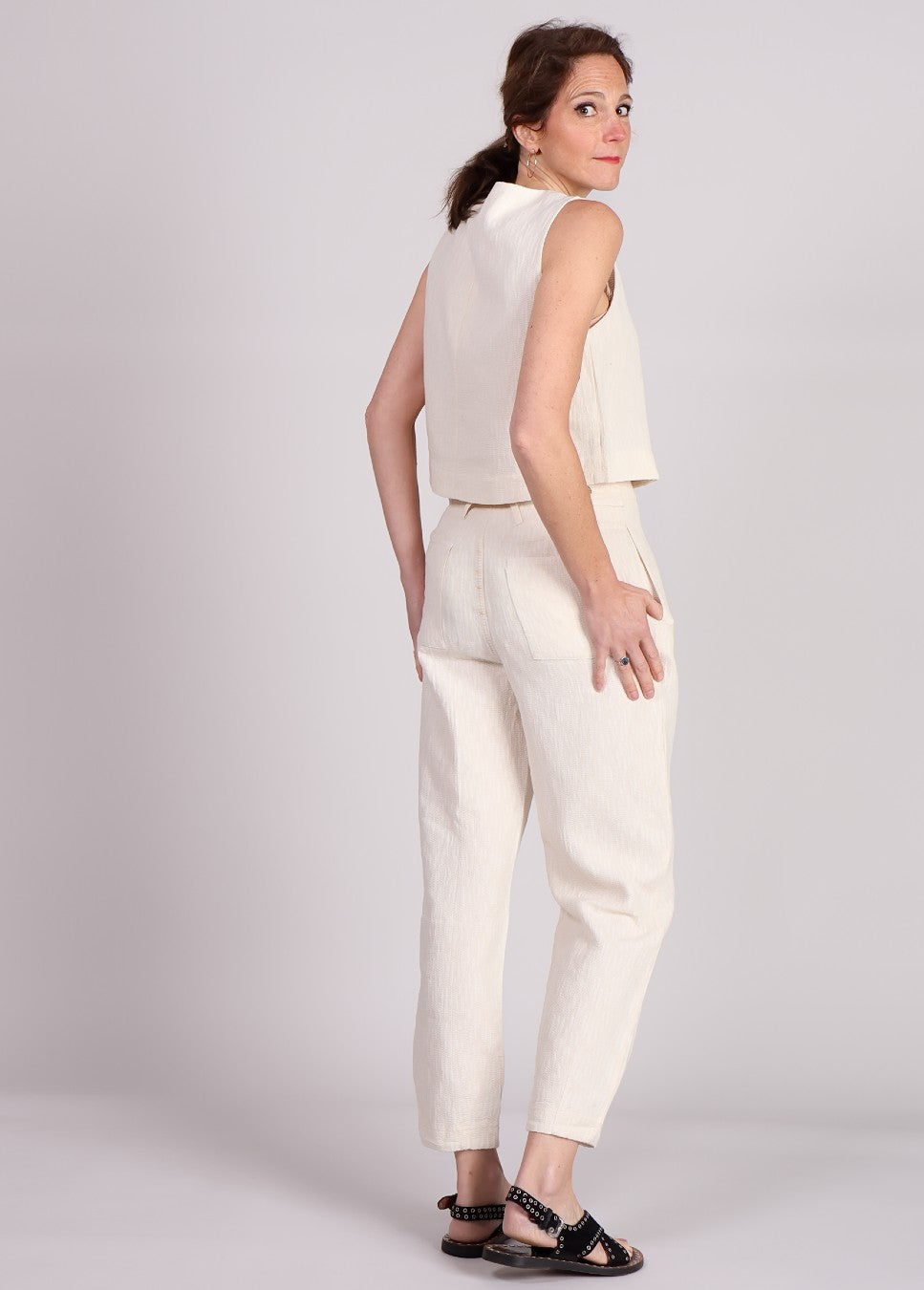 Achterkant van de FRNCH Pepita broek linnen, met plooien en beige van kleur op model