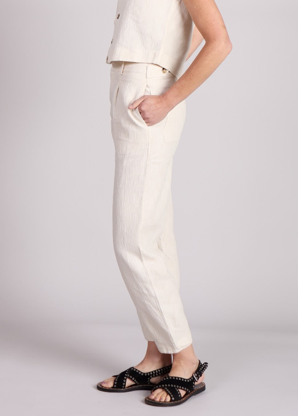 Close up van de beige linnen FRNCH broek Pepita met plooien op model zijkant
