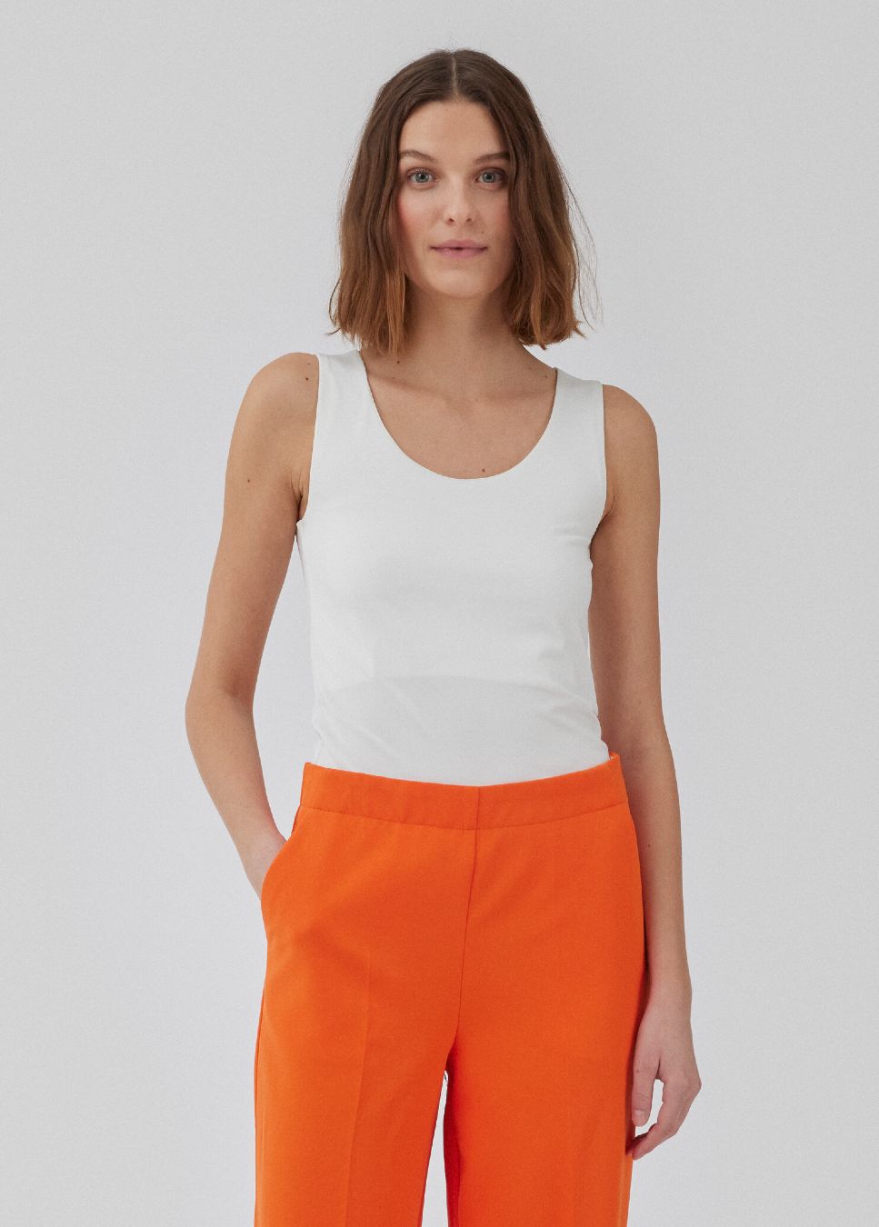 Witte top Hima I Witte aansluitende basic top Hima van het merk Modstrom. De top met stretch heeft brede bandjes en een diepe ronde hals gemaakt in gerecyclede kwaliteit. De witte top heeft een strak silhouet. Shop de nieuwe collectie dames tops, basic dames tops, Modstrom tops, witte basic hemdjes bij Boetiek Aniek.