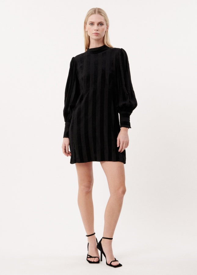 Zwarte midi-jurk met open rug Cecilia van het merk FRNCH. De zwarte jurk heeft subtiele verticale fluwelen strepen. De midi-jurk heeft lange (lichte) pofmouwen met manchetten aan de uiteinde en een diepe V-hals op de rug met strik in de nek. Shop de nieuwe collectie jurken, zwarte jurken, FRNCH jurken bij Boetiek Aniek