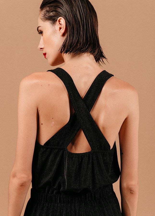 Mooie zwarte jumpsuit Loyale van het merk Grace & Mila. De zwarte jumpsuit met lichte glitter een brede bandjes die gekruist lopen op de rug, een V-Hals, elastische tailleband en lang wijde pijpen. De perfecte jumpsuit voor een feestje of voor tijdens de feestdagen. Shop zwarte jumpsuits online bij Boetiek Aniek.