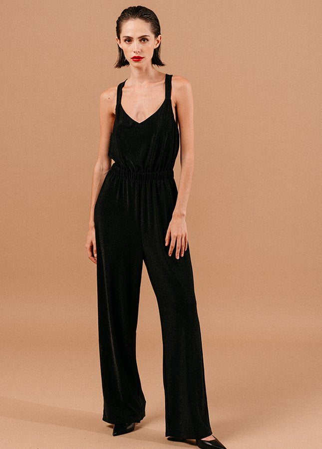 Mooie zwarte jumpsuit Loyale van het merk Grace & Mila. De zwarte jumpsuit met lichte glitter een brede bandjes die gekruist lopen op de rug, een V-Hals, elastische tailleband en lang wijde pijpen. De perfecte jumpsuit voor een feestje of voor tijdens de feestdagen. Shop zwarte jumpsuits online bij Boetiek Aniek.