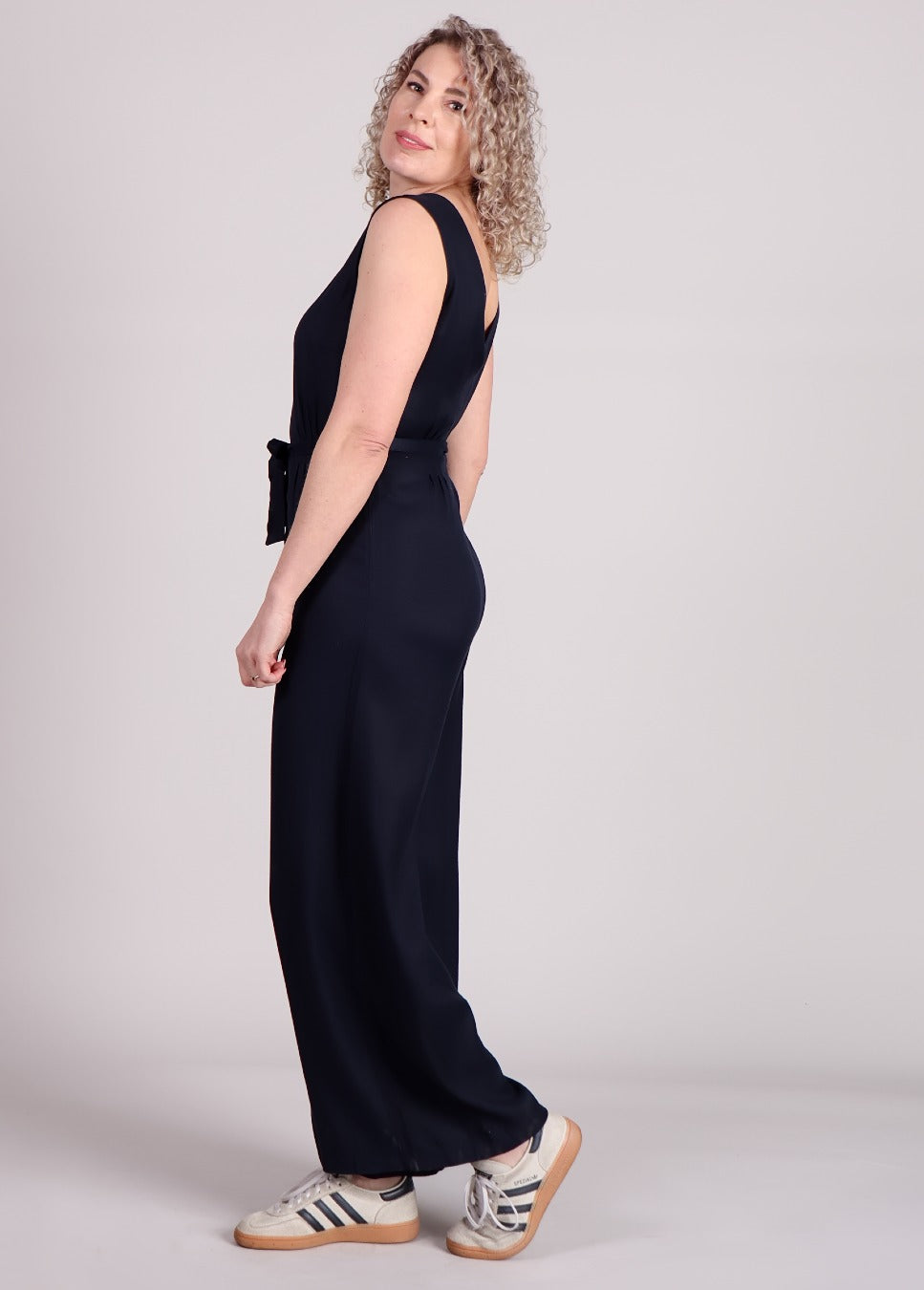 donker blauwe jumpsuit frnch pakize met v hals strikceintuur op model schuin achterkant