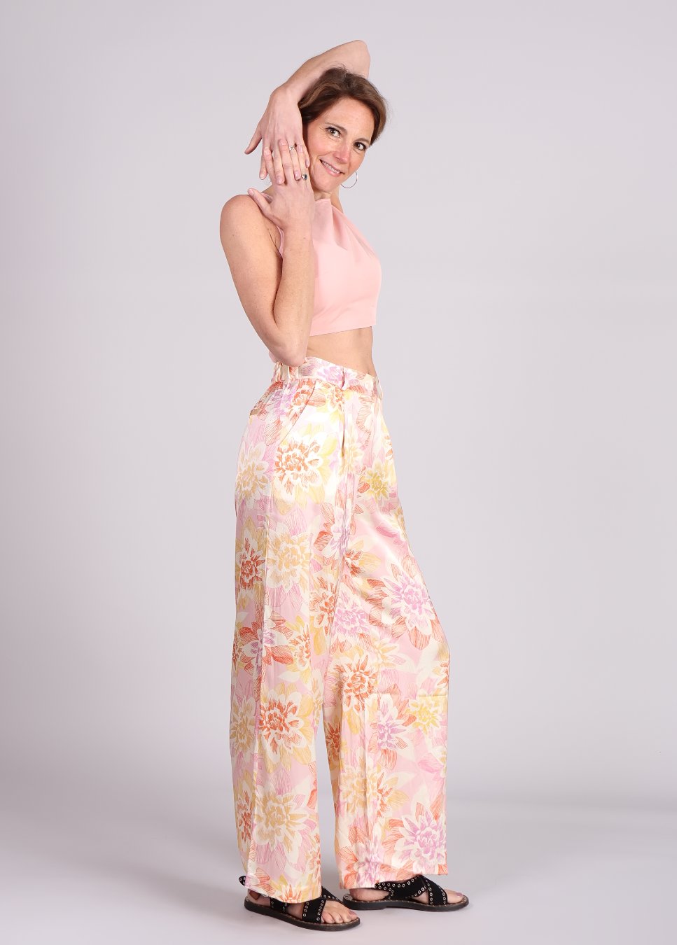 Zijaanzicht van roze bloemenprint Philo FRNCH pantalon met een roze top op model