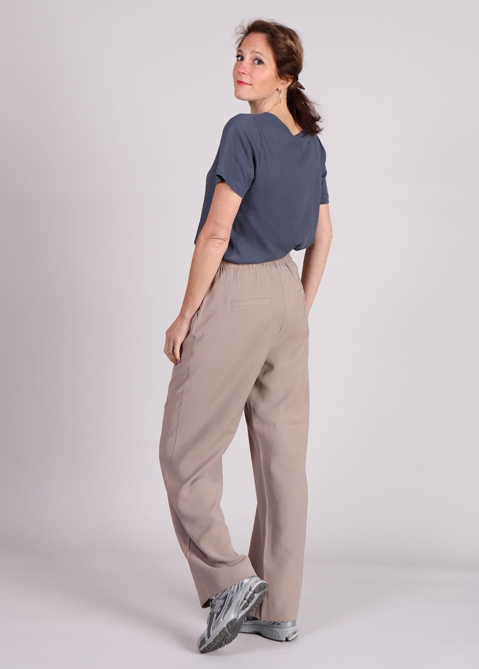 Achterkant van de beige FanyaMD modstrom broek voorzien van bandplooi op model