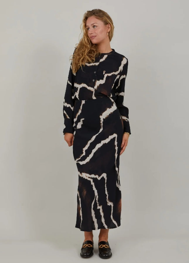 Mooie zwarte lange rok met print van het merk Coster Copenhagen. De zwarte print rok heeft een elastische tailleband en valt strak om de heupen. Combineer de lange rok met een witte of zwarte effen trui. Shop de nieuwe collectie dames rokken, lange rokken, zwarte rokken, print rokken, Coster Copenhagen rokken online.
