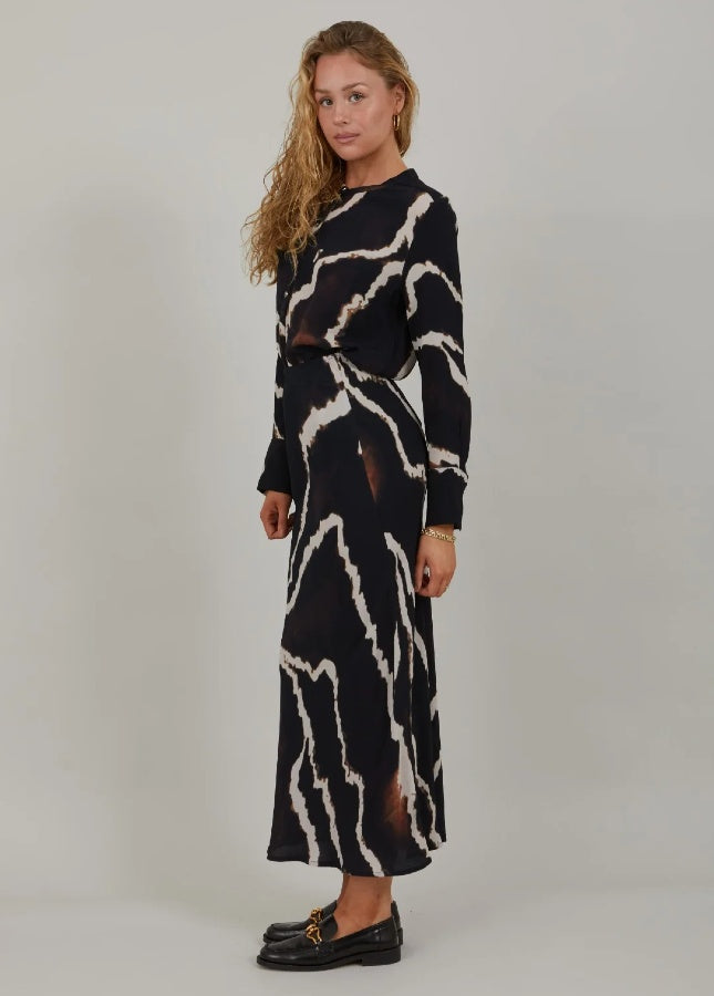 Mooie zwarte lange rok met print van het merk Coster Copenhagen. De zwarte print rok heeft een elastische tailleband en valt strak om de heupen. Combineer de lange rok met een witte of zwarte effen trui. Shop de nieuwe collectie dames rokken, lange rokken, zwarte rokken, print rokken, Coster Copenhagen rokken online.