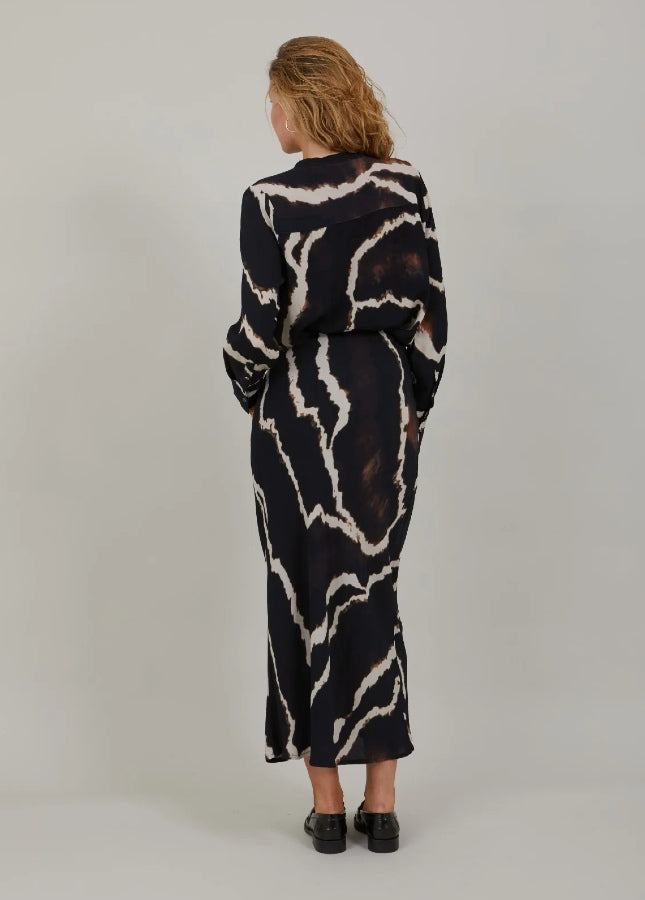 Mooie zwarte lange rok met print van het merk Coster Copenhagen. De zwarte print rok heeft een elastische tailleband en valt strak om de heupen. Combineer de lange rok met een witte of zwarte effen trui. Shop de nieuwe collectie dames rokken, lange rokken, zwarte rokken, print rokken, Coster Copenhagen rokken online.