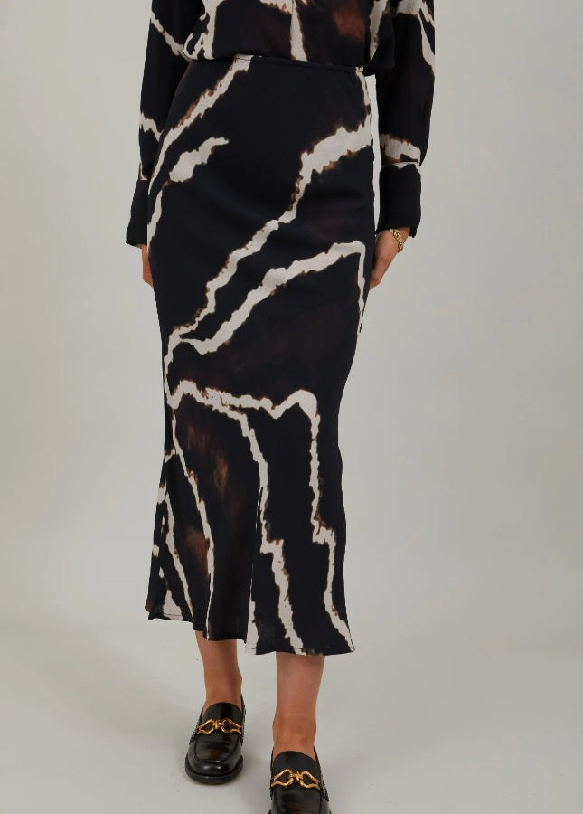 Mooie zwarte lange rok met print van het merk Coster Copenhagen. De zwarte print rok heeft een elastische tailleband en valt strak om de heupen. Combineer de lange rok met een witte of zwarte effen trui. Shop de nieuwe collectie dames rokken, lange rokken, zwarte rokken, print rokken, Coster Copenhagen rokken online.