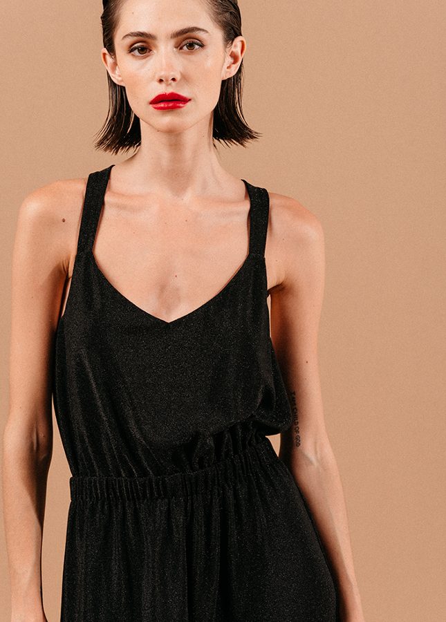 Mooie zwarte jumpsuit Loyale van het merk Grace & Mila. De zwarte jumpsuit met lichte glitter een brede bandjes die gekruist lopen op de rug, een V-Hals, elastische tailleband en lang wijde pijpen. De perfecte jumpsuit voor een feestje of voor tijdens de feestdagen. Shop zwarte jumpsuits online bij Boetiek Aniek.