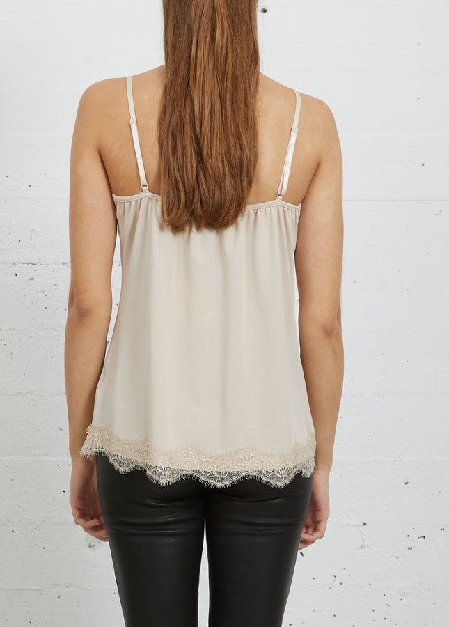 Online dames Fashion Boetiek Aniek I Mooie nude lace top van het merk CC Heart. De lace top is een strak en elegant hemdje met een zachte V-hals en verstelbare spaghettibandjes.De top is voorzien van kanten details en heeft een relaxte pasvorm. Shop mooie basic tops en hemdjes met kant in de kleuren zwart, wit en beige